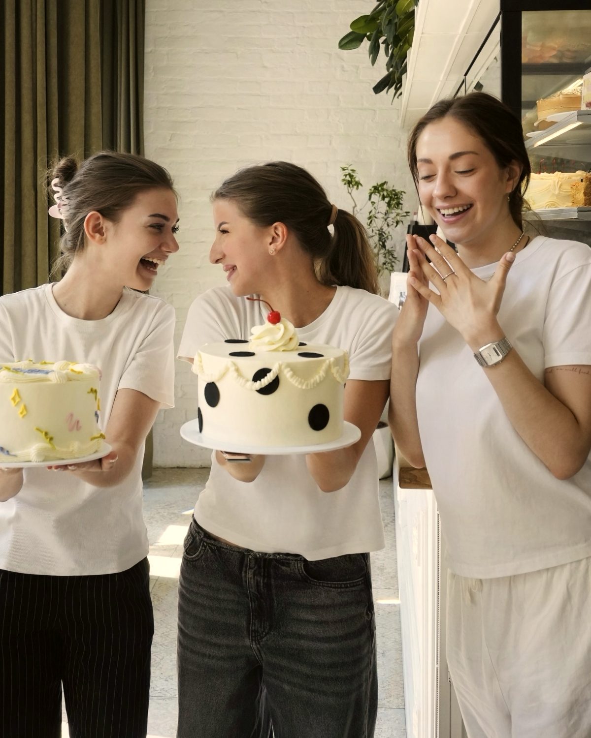Three team members at the counter with the cakes they have just decorated